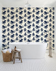 Cresting Wave Ink octopus wallpaper behind a freestanding tub in a bright coastal bathroom