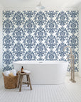Dreamy Fern Dial Slate fern damask wallpaper behind a freestanding tub in a bright coastal bathroom
