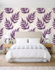 Driftwood Fern Plum fern frond wallpaper behind a queen bed in a bright coastal bedroom