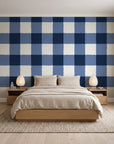 Dune Plaid Navy gingham check wallpaper behind a low platform bed in a serene Japandi bedroom