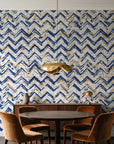 Dusk Passage Indigo chevron wallpaper behind a walnut credenza and round table in an elegant dining room