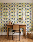 Ember & Iron Mustard retro ogee wallpaper behind a vintage writing desk in a cozy craft-room home office