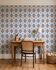 Ember & Iron Navy retro ogee wallpaper behind a vintage writing desk in a cozy craft-room home office