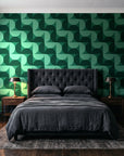 Ember Mosaic Emerald retro geometric wallpaper behind a tufted headboard in a dark, moody bedroom