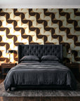 Ember Mosaic Mocha retro geometric wallpaper behind a tufted headboard in a dark, moody bedroom