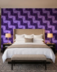 Ember Mosaic Plum retro geometric wallpaper behind the headboard of a king bed in a contemporary hotel guest room