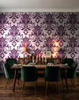 Ethereal Flowers Aubergine damask wallpaper in a dark moody dining room with a candlelit table