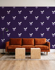 Falling Grace Plum chevron wallpaper behind a rust velvet sofa in a bright coworking lounge