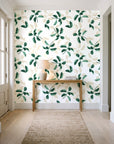 Falling Softly Emerald botanical leaf wallpaper behind a console table in a light entry hallway