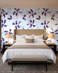 Falling Softly Plum botanical leaf wallpaper behind the headboard of a king bed in a contemporary hotel guest room