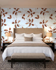 Falling Softly Terracotta botanical leaf wallpaper behind the headboard of a king bed in a contemporary hotel guest room