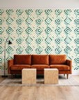 Fern Lattice Emerald hand-drawn diamond wallpaper behind a rust velvet sofa in a bright coworking lounge