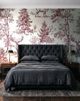 Frost & Fable Burgundy woodland toile wallpaper behind a tufted headboard in a dark, moody bedroom
