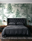 Frost & Fable Forest woodland toile wallpaper behind a tufted headboard in a dark, moody bedroom