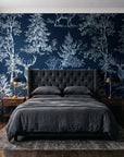 Frost & Fable Midnight woodland toile wallpaper behind a tufted headboard in a dark, moody bedroom
