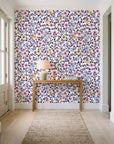 Garden Reverie Plum floral wallpaper behind a console table in a light entry hallway