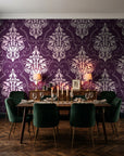 Gentlebotan Plum botanical damask wallpaper in a dark moody dining room with a candlelit table