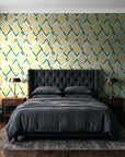 Gilded Crossing Emerald chevron geometric wallpaper behind a tufted headboard in a dark, moody bedroom