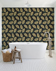 Gilded Frond Noir leaf wallpaper behind a freestanding tub in a bright coastal bathroom