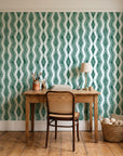 Gilded Rain Emerald geometric wallpaper behind a vintage writing desk in a cozy craft-room home office