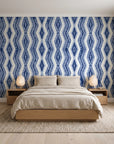 Gilded Rain Indigo geometric wallpaper behind a low platform bed in a serene Japandi bedroom