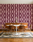 Gilded Rain Oxblood geometric wallpaper in a mid-century dining room with a teak sideboard and tulip table