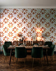 Gilt Scatter Terracotta floral scatter wallpaper in a dark moody dining room with a candlelit table