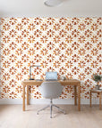 Gilt Scatter Terracotta floral scatter wallpaper behind a modern oak desk in a bright home office