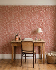 Grain Shift Terracotta minimalist dash wallpaper behind a vintage writing desk in a cozy craft-room home office