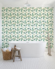 Hanging Garden Emerald botanical wallpaper behind a freestanding tub in a bright coastal bathroom