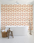 Hanging Garden Terracotta botanical wallpaper behind a freestanding tub in a bright coastal bathroom