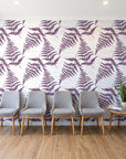 Harbor Fern Plum fern wallpaper behind a row of upholstered chairs in a bright clinic waiting room