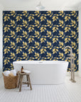Harvest Crown Midnight leafy branch wallpaper behind a freestanding tub in a bright coastal bathroom