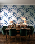 Harvest Crown Slate leafy branch wallpaper in a dark moody dining room with a candlelit table