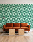Hidden Court Emerald floral ogee wallpaper behind a rust velvet sofa in a bright coworking lounge