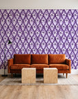 Hidden Court Plum floral ogee wallpaper behind a rust velvet sofa in a bright coworking lounge
