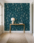 Ink & Sprig Peacock botanical sprig wallpaper behind a console table in a light entry hallway