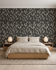 Khaki Leaf Charcoal botanical leaf wallpaper behind a low platform bed in a serene Japandi bedroom