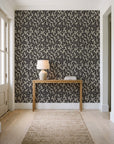 Khaki Leaf Charcoal botanical leaf wallpaper behind a console table in a light entry hallway