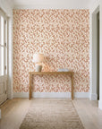 Khaki Leaf Clay botanical leaf wallpaper behind a console table in a light entry hallway