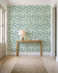 Khaki Leaf Evergreen botanical leaf wallpaper behind a console table in a light entry hallway