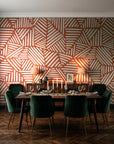 Kinetic Etch Terracotta hand-drawn lines wallpaper in a dark moody dining room with a candlelit table