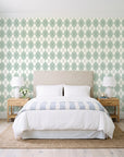 Linen Diamonds Sage argyle wallpaper behind a queen bed in a bright coastal bedroom