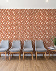 Linen & Leaf Terracotta leaf wallpaper behind a row of upholstered chairs in a bright clinic waiting room
