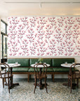 Meadow Light Blush meadow flower wallpaper above a green leather banquette in a sunlit neighborhood cafe