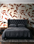 Mistletoe Trail Terracotta mistletoe wallpaper behind a tufted headboard in a dark, moody bedroom