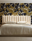 Muted Block Graphite geometric wallpaper behind a channel-tufted bed in a calm primary bedroom