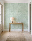 Nomad Stripe Sage geometric wallpaper behind a console table in a light entry hallway