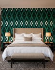 Ogee Loom Emerald ikat ogee wallpaper behind the headboard of a king bed in a contemporary hotel guest room