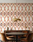 Ogee Loom Terracotta ikat ogee wallpaper behind a walnut credenza and round table in an elegant dining room